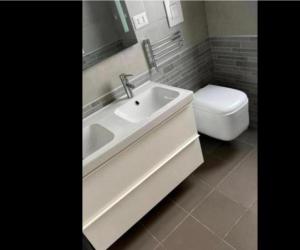 a white bathroom with a sink and a toilet at Spina home in Vieste