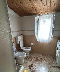 a bathroom with a toilet and a sink and a window at Casa sole Sicilia in Alcamo +4 photos