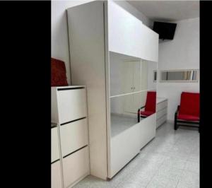 a room with a large white cabinet and a red chair at Spina home in Vieste