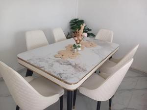 a dining room table with white chairs and a white table at Sunrise Bay Villa in Mahébourg +12 photos
