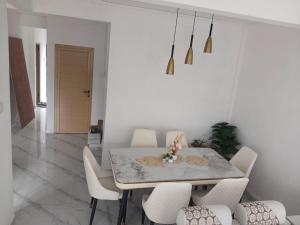 a dining room with a table and white chairs at Sunrise Bay Villa in Mahébourg