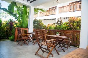 a patio with tables and chairs and plants at Bustan Inn in Kilima Juu Pwani