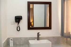a bathroom with a sink and a mirror and a phone at Bustan Inn in Kilima Juu Pwani