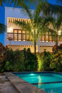 a villa with a swimming pool in front of a building at Bustan Inn in Kilima Juu Pwani