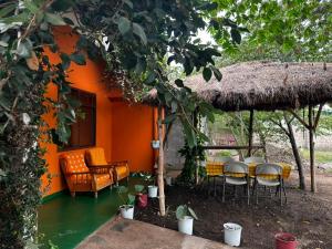 an orange house with chairs and a table at East Homestay in Boma la Ngombe