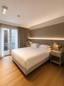 a bedroom with a large white bed and a window at Purobaires Hotel Boutique in Buenos Aires