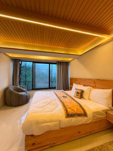 a large bed in a room with a large window at Pine View Hotel in Abbottabad +10 photos