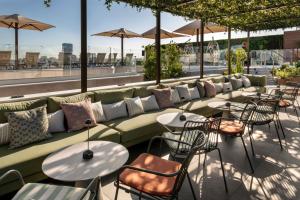a row of tables and chairs with pillows on a patio at Catalonia Gran Vía Madrid in Madrid