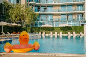 a pool at a hotel with a rubber duck in the water at Era Palace Gonio in Kvariati