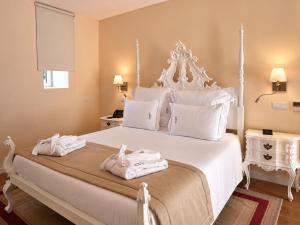 a bedroom with a white bed with towels on it at Quinta da Maquia Hotel in Sintra +81 photos