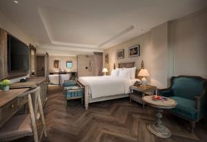 a hotel room with a bed and two chairs at Hotel LaVue Tam Coc in Ninh Binh