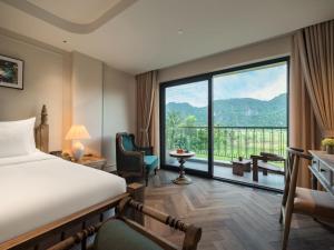 a hotel room with a bed and a large window at Hotel LaVue Tam Coc in Ninh Binh +106 photos