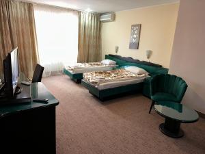 a hotel room with two beds and a desk at Dallin Center Hotel in Bucharest