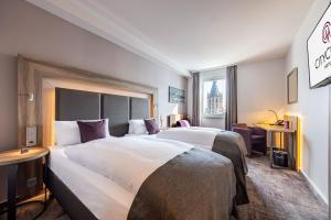 a hotel room with two beds and a window at CityClass Hotel am Dom in Cologne