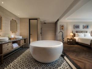 a bathroom with a large tub and a bed at Hotel LaVue Tam Coc in Ninh Binh