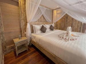 a bedroom with a white bed with a canopy at Villa Wakem Yehpoh in Yehpoh