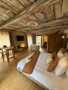 a large bedroom with a large bed and a tub at LA PAUSE Chisà in Chisa