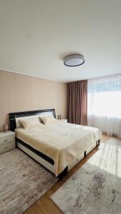 a bedroom with a large bed and a window at Пар&Речка in Almaty