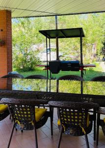 a picnic table with chairs and a grill on a patio at Пар&Речка in Almaty