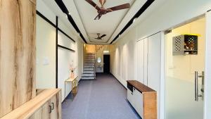 a hallway with a ceiling fan and a staircase at StayMooddy in Indore