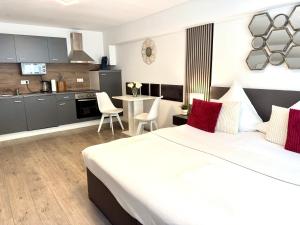 a bedroom with a large white bed and a kitchen at Prime Host Dream Deluxe in Karlsruhe +15 photos