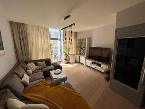 a living room with a couch and a flat screen tv at Tomorrowland Boom in Boom