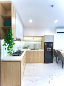 a kitchen with wooden cabinets and a black refrigerator at Toà gh6 in Gò Công