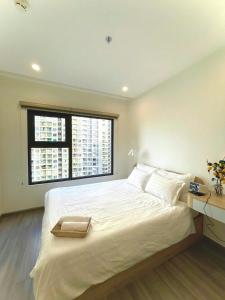 a bedroom with a large white bed with a window at Toà gh6 in Gò Công