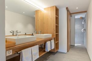 a bathroom with a sink and a mirror at Sport-Lodge Klosters in Klosters +101 photos