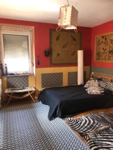 a bedroom with a bed in a room with red walls at maison d'artiste chez Bé in Brunstatt