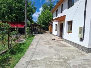 an empty sidewalk next to a white building at Casa Szabo Vata Bai in Vaţa de Jos