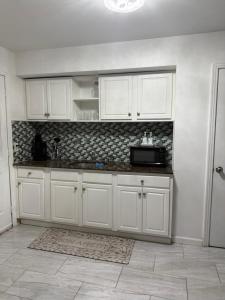 a kitchen with white cabinets and a microwave at Rest apartment in Jacksonville