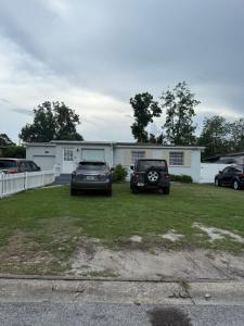 two cars parked in a yard in front of a house at Rest apartment in Jacksonville