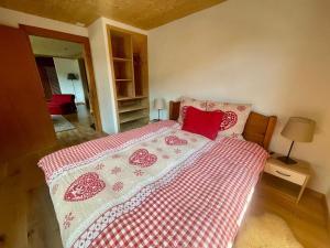 a bedroom with a bed with a red and white blanket at Chalet Floriana in Les Diablerets