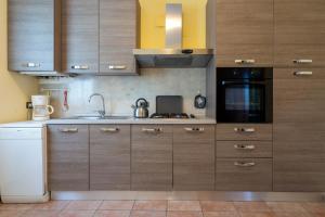 a kitchen with wooden cabinets and a sink at Casa Lucia 1 in Crone