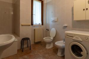 a bathroom with a toilet sink and a washing machine at Casa Lucia 1 in Crone +16 photos