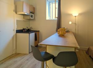 a small kitchen with a table and two chairs at Le havre du voyageur in Charly