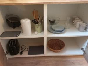 a white cabinet with dishes and utensils on it at Le havre du voyageur in Charly +19 photos