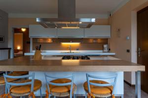 a kitchen with a counter with four chairs around it at Casa Lucia 2 in Crone