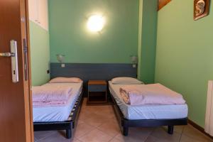 two beds in a room with green walls at Casa Flora in Crone