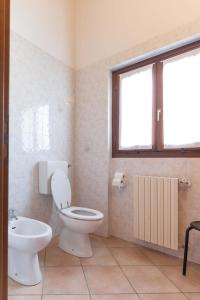 a bathroom with a toilet and a sink and a window at Casa Flora in Crone +16 photos