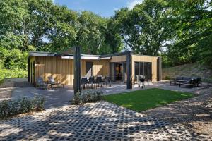 a building with chairs and tables in a yard at Prinsenhof 10 - Ouddorp in Ouddorp
