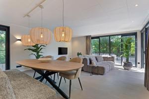 a living room with a wooden table and chairs at Prinsenhof 10 - Ouddorp in Ouddorp