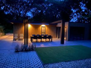 a patio with a table and chairs at night at Prinsenhof 10 - Ouddorp in Ouddorp