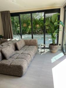a living room with a couch and a plant at Prinsenhof 10 - Ouddorp in Ouddorp