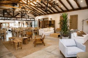 a large living room with white furniture and a dining room at Hotel Casa De Campo in Santa Cruz
