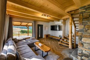 a living room with a couch and a stone wall at Kamienny Horyzont in Bereżnica Wyżna