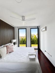a white bedroom with a large bed with windows at Puesta de Sol Doñana Adults Only in Sanlúcar de Barrameda +21 photos