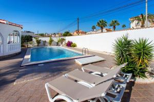 a house with a swimming pool and two lounge chairs at CH Villa Mare Ciudad Quesada in Ciudad Quesada
