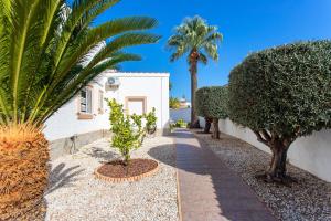 a garden with palm trees and a white building at CH Villa Mare Ciudad Quesada in Ciudad Quesada